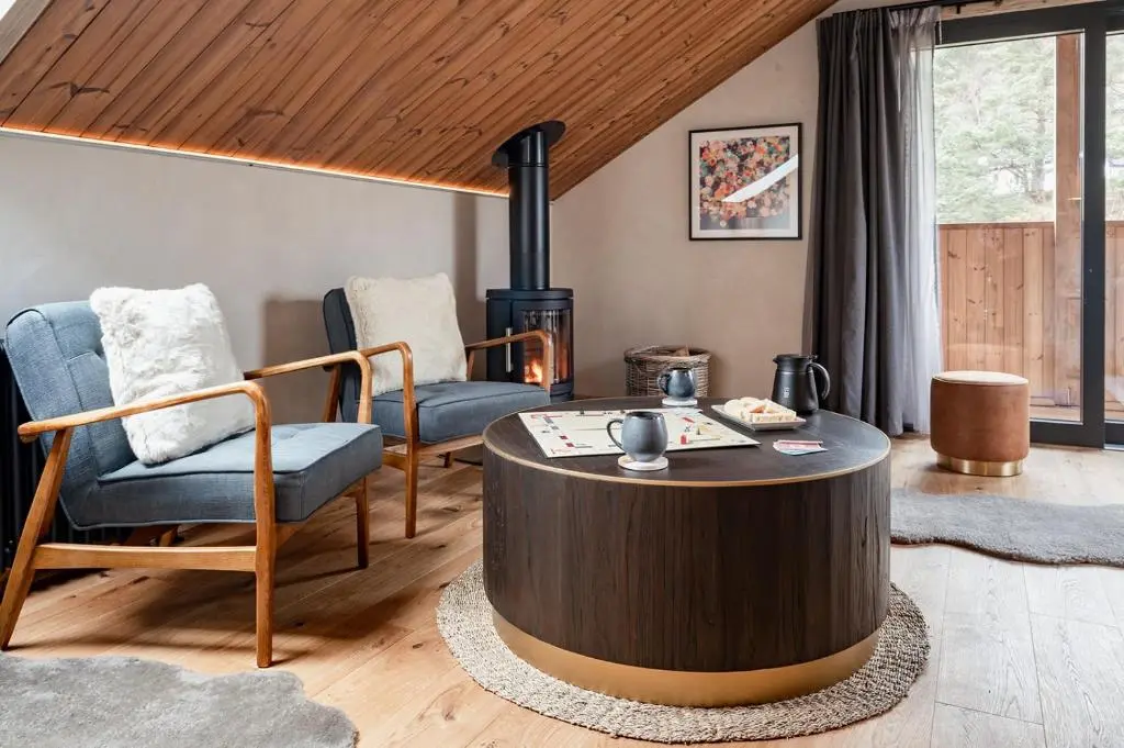 a living room with a coffee table and chairs at Osprey Lodge in Aviemore