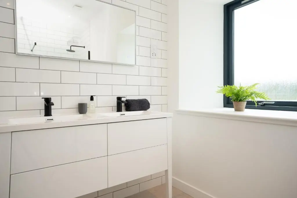 a white bathroom with two sinks and a mirror at Pityoulish Steading - Seasgair Lodges in Aviemore