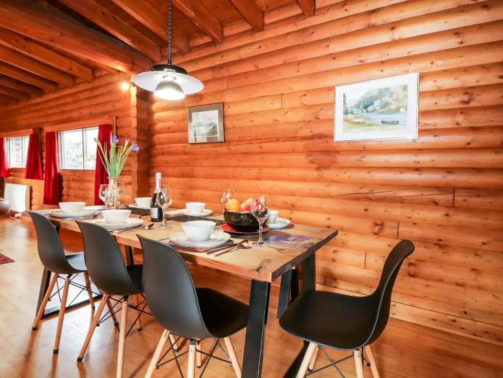 a wooden dining room with a table and chairs at Rocksite in Blairgowrie