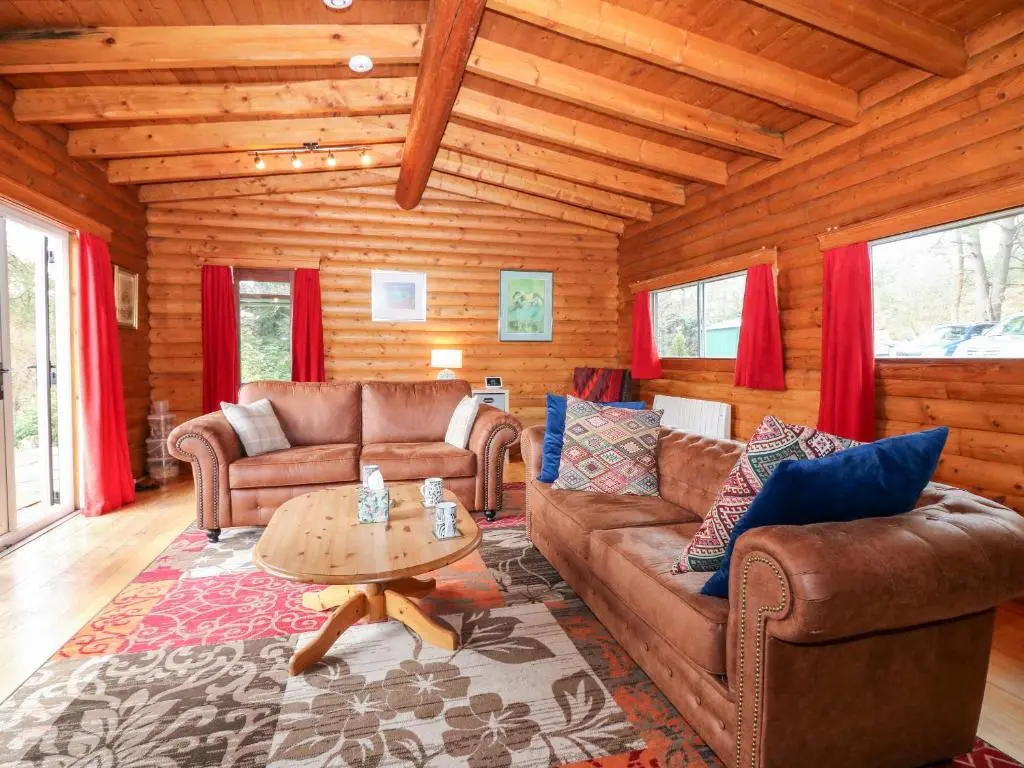 a living room with couches and a table in a cabin at Rocksite in Blairgowrie