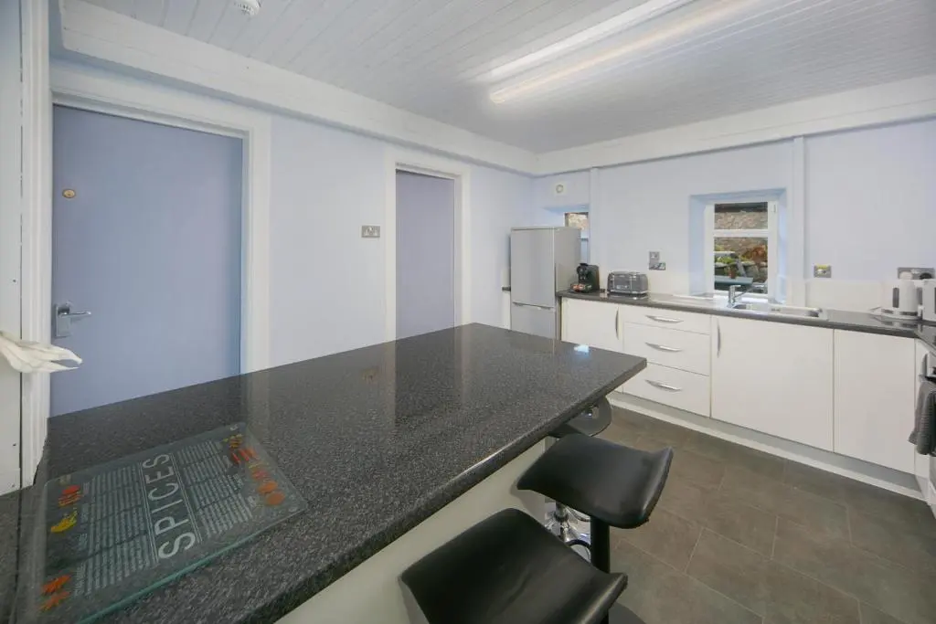 a kitchen with a black counter top and white cabinets at Constancevilla B7 - Grampian Lettings Ltd in Aberdeen