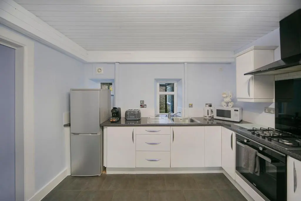 a kitchen with white cabinets and a stainless steel refrigerator at Constancevilla B7 - Grampian Lettings Ltd in Aberdeen
