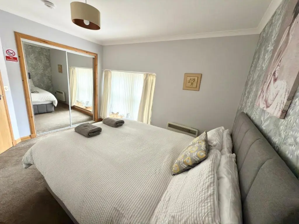 a bedroom with a bed and a couch and a mirror at The Old Salt House, Flat1 in Wick
