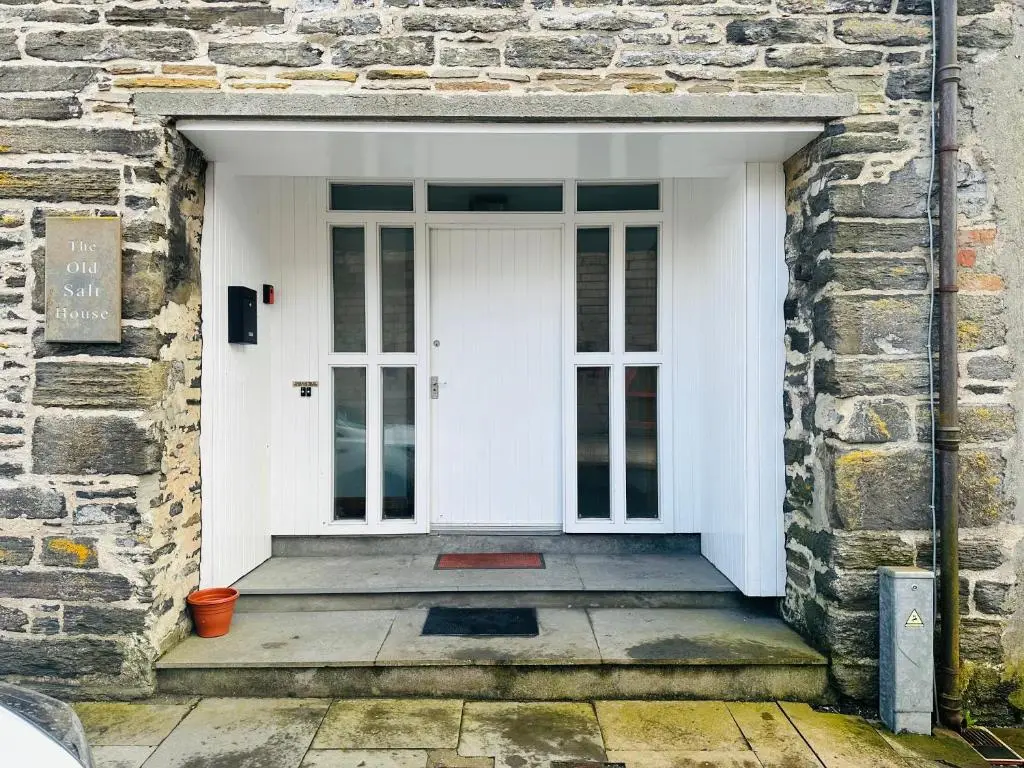 a white front door of a brick building with a porch at The Old Salt House, Flat1 in Wick