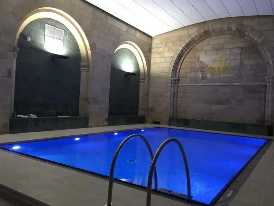 a large pool in a building with blue water at Abbey Garden at the Highland Club in Fort Augustus