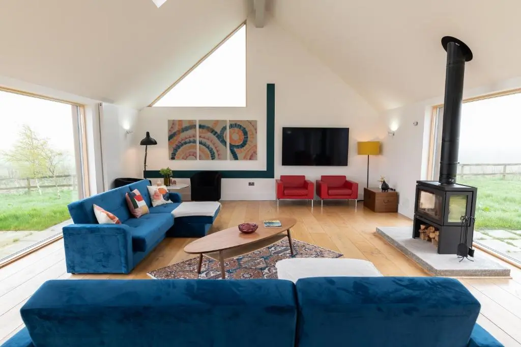 a living room with a blue couch and a fireplace at Stunning Rural Retreat Sleeps\u00a024 in Aberdeen