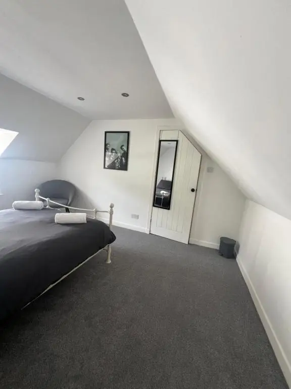 a bedroom with a large bed and a staircase at MaCaMor in Helmsdale