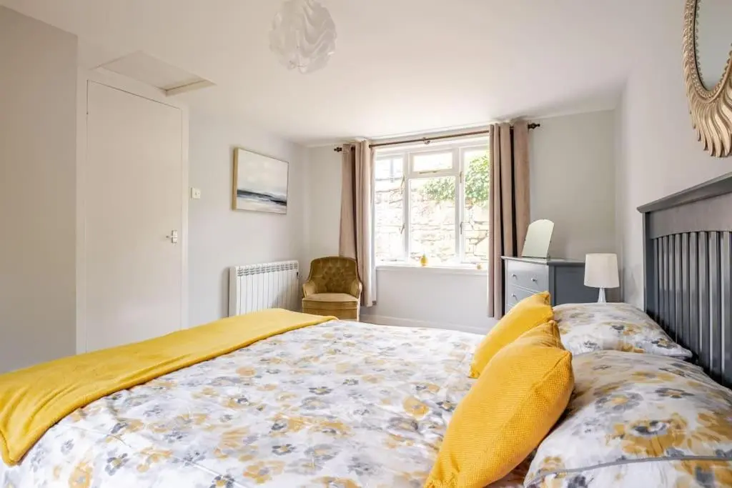 a bedroom with a large bed with yellow pillows at Applegrove, perfect 2 bed bungalow, Fortrose in Fortrose