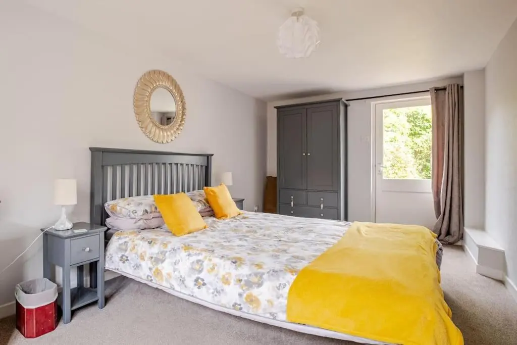 a bedroom with a large bed with yellow pillows at Applegrove, perfect 2 bed bungalow, Fortrose in Fortrose