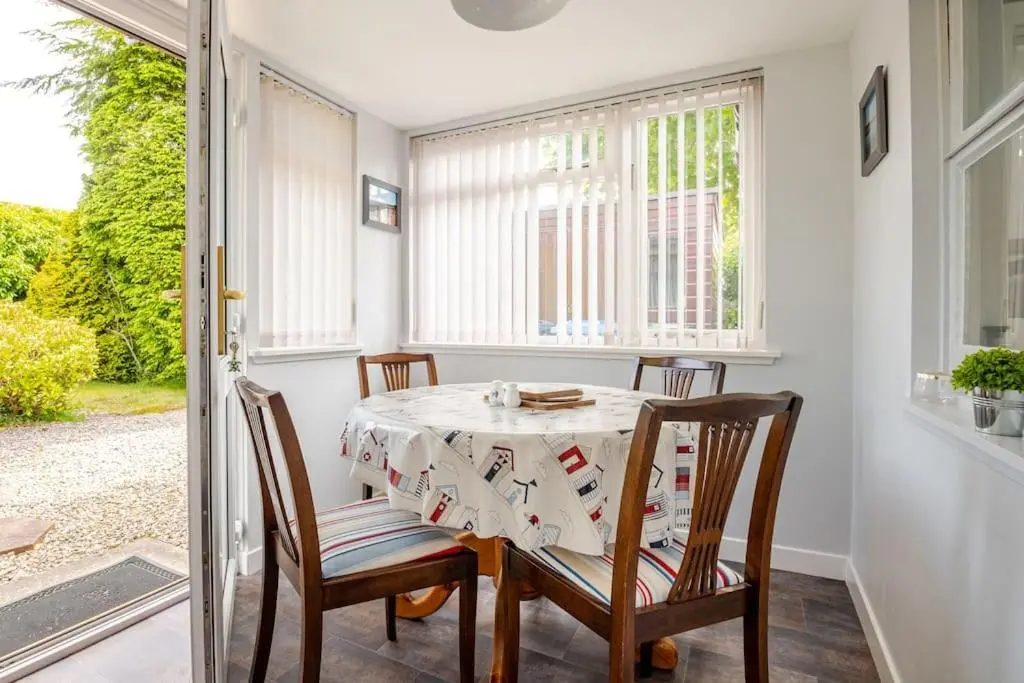 a dining room with a table and four chairs at Applegrove, perfect 2 bed bungalow, Fortrose in Fortrose
