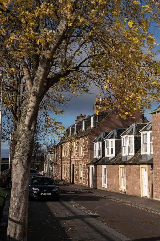 a car parked on a street next to a tree at River View City Centre- Free Parking in Inverness
