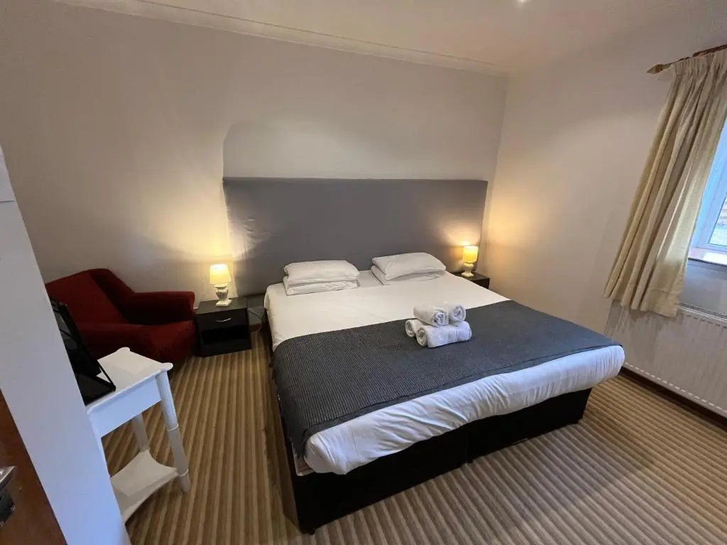 a bedroom with a bed with a teddy bear on it at Columba House in Kingussie