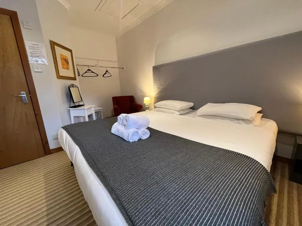 a hotel room with two beds with a towel on the bed at Columba House in Kingussie
