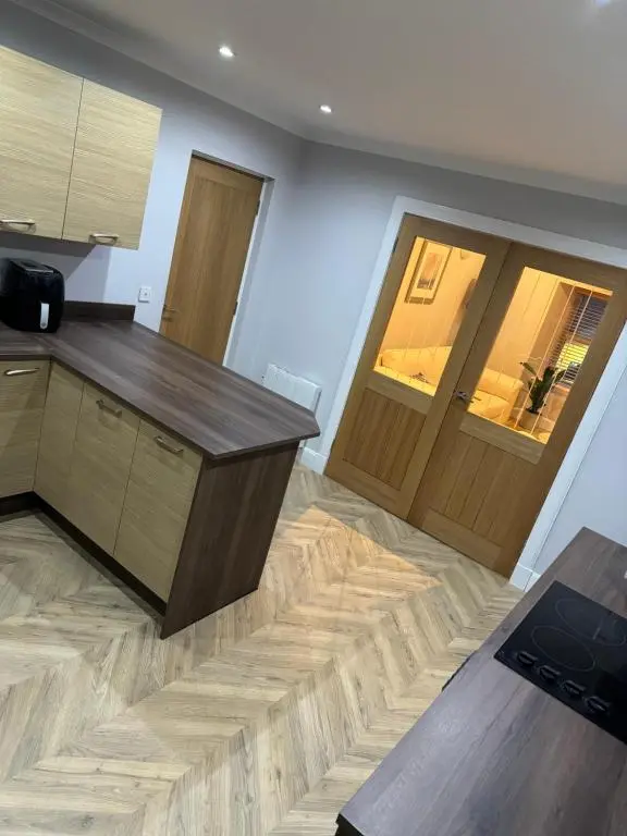 a kitchen with a wooden counter and a wooden door at Town Centre 2 bedroom apartment in Wick