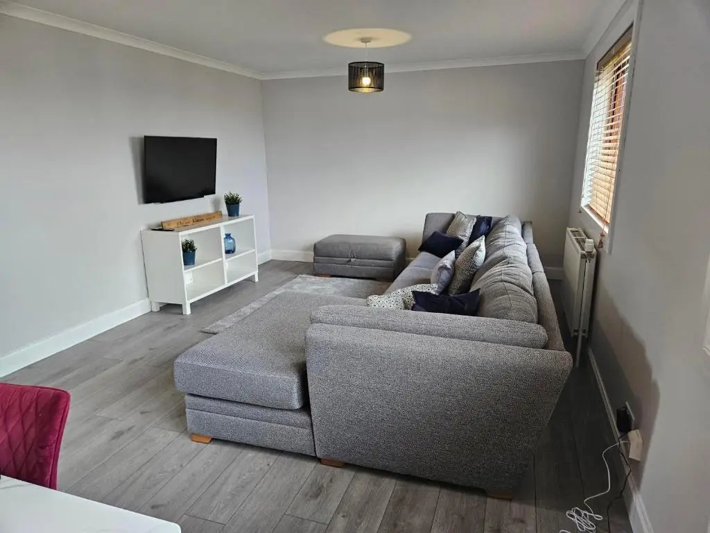 a living room with a couch and a tv at NO 40 - 3 bed all with smart tv FULLY FITTED KITCHEN, Spacious living accommodation, FREE PARKING - ideal for TRADES, reduction for LONG STAYS part of Langley Cottages and Apartments in Wick