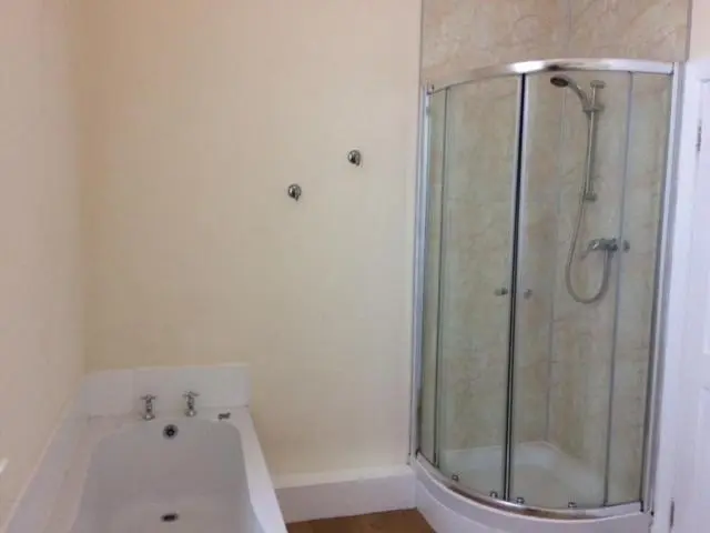 a bathroom with a shower and a white tub at 92 High Street in Aberlour