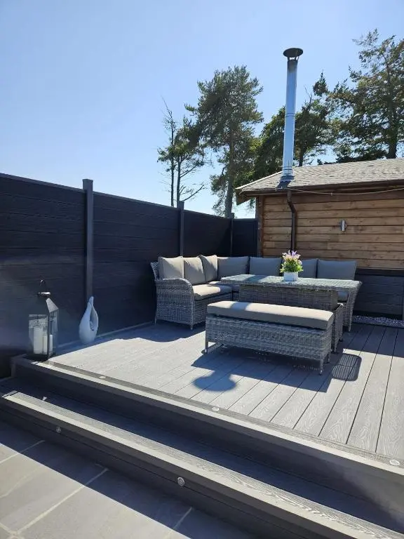 a patio with two couches and a bench on a deck at Hillhaven Lodge in Inverness