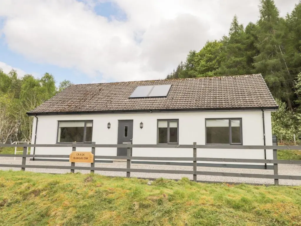 a white house with a solar panel on it at Crask Bungalow in Beauly