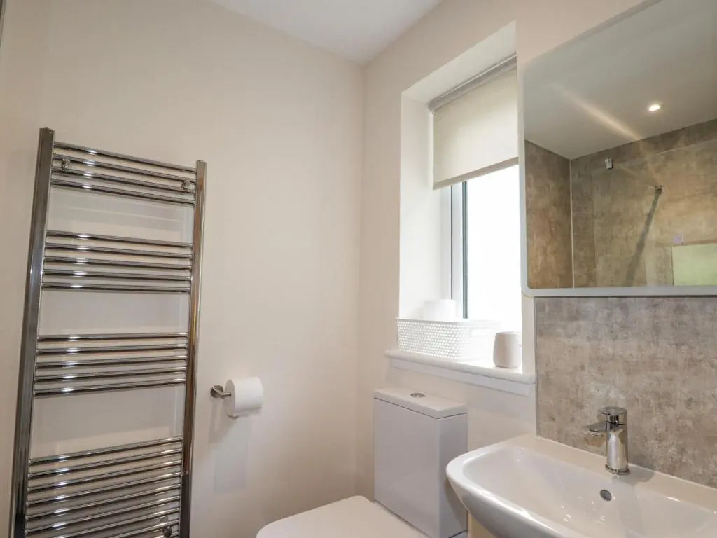 a bathroom with a toilet and a sink and a mirror at Crask Bungalow in Beauly