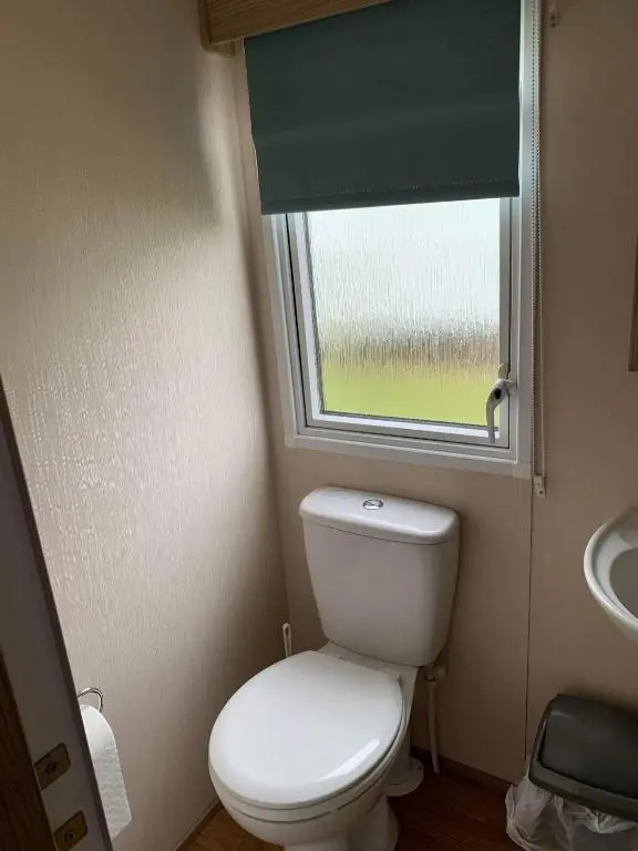 a small bathroom with a toilet and a window at Highway in Lossiemouth