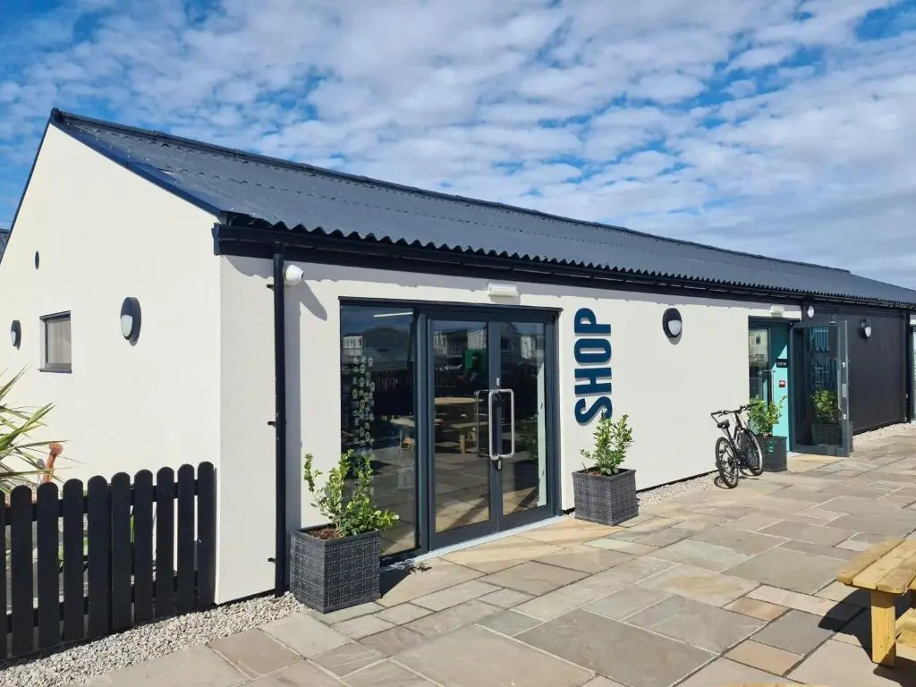 a white building with a black roof at Highway in Lossiemouth