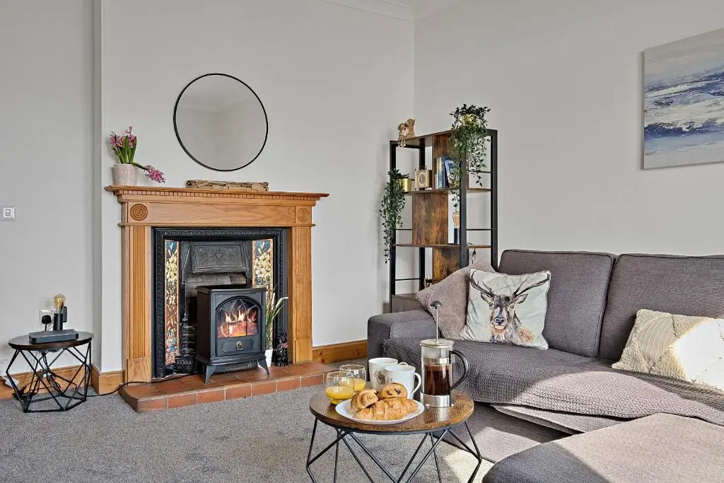 a living room with a couch and a fireplace at Finest Retreats - The Sea Cottage in Avoch