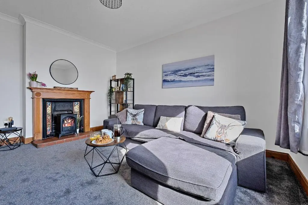 a living room with a couch and a fireplace at Finest Retreats - The Sea Cottage in Avoch