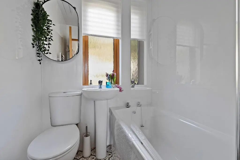 a white bathroom with a toilet and a sink at Finest Retreats - The Sea Cottage in Avoch