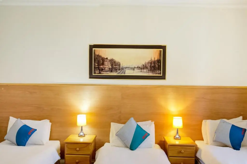 a hotel room with two beds and a picture on the wall at OYO Eastbank Hotel, Speyside Scotland in Rothes