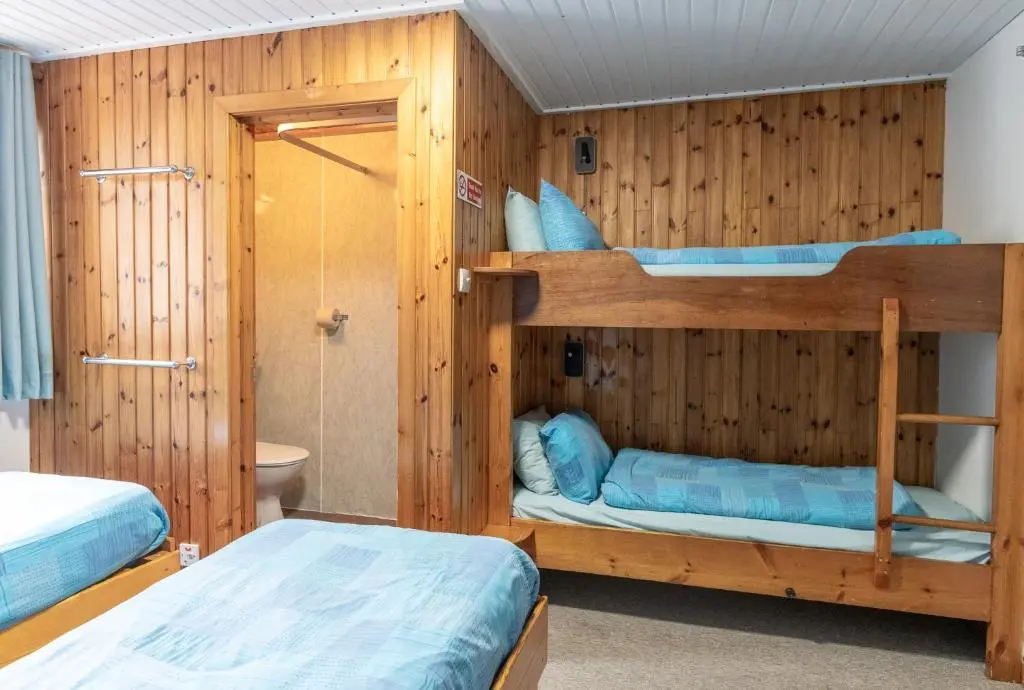 two bunk beds in a room with wooden walls at Insh Hall Rooms at Loch Insh in Kincraig
