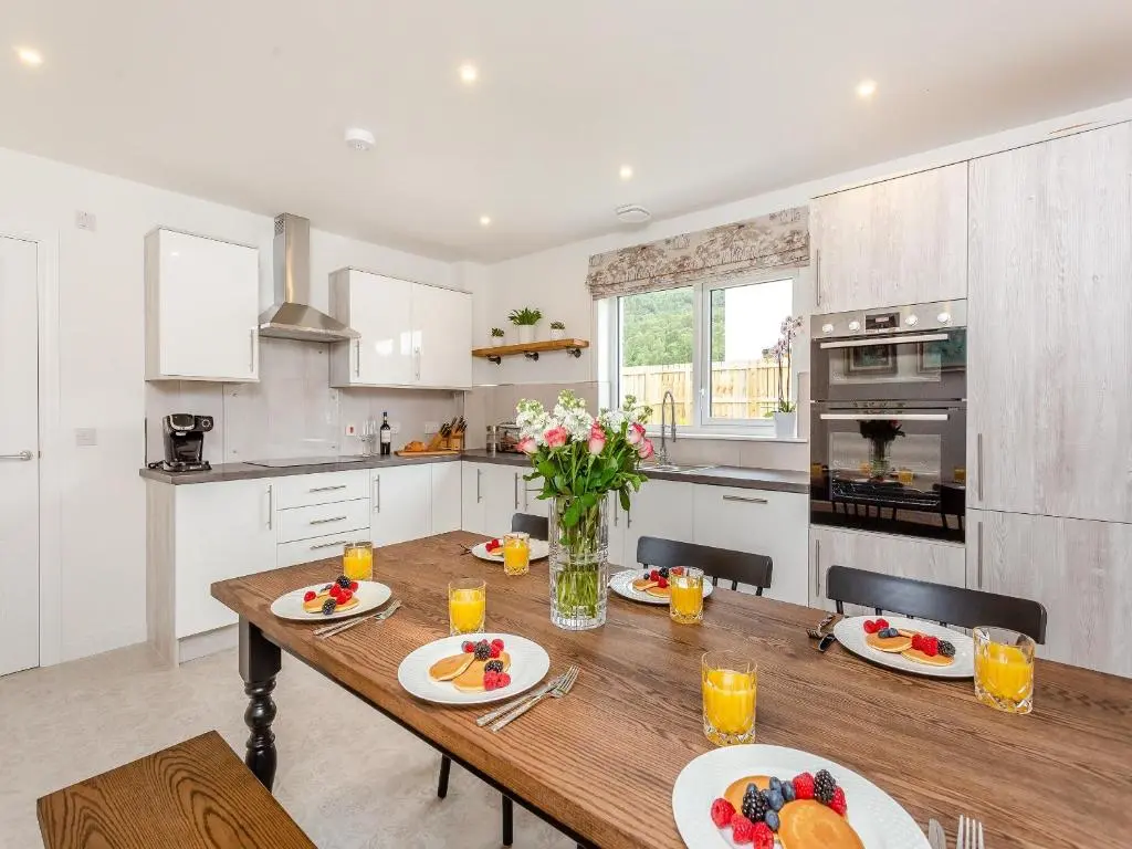 a kitchen with a wooden table with food on it at The Beech House in Aviemore