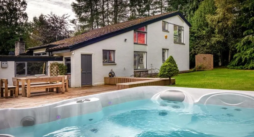 a large swimming pool in front of a house at Four Pines Lodge in Skye of Curr