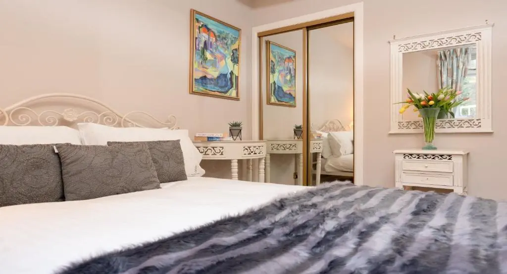 a bedroom with a large bed and a mirror at Four Pines Lodge in Skye of Curr