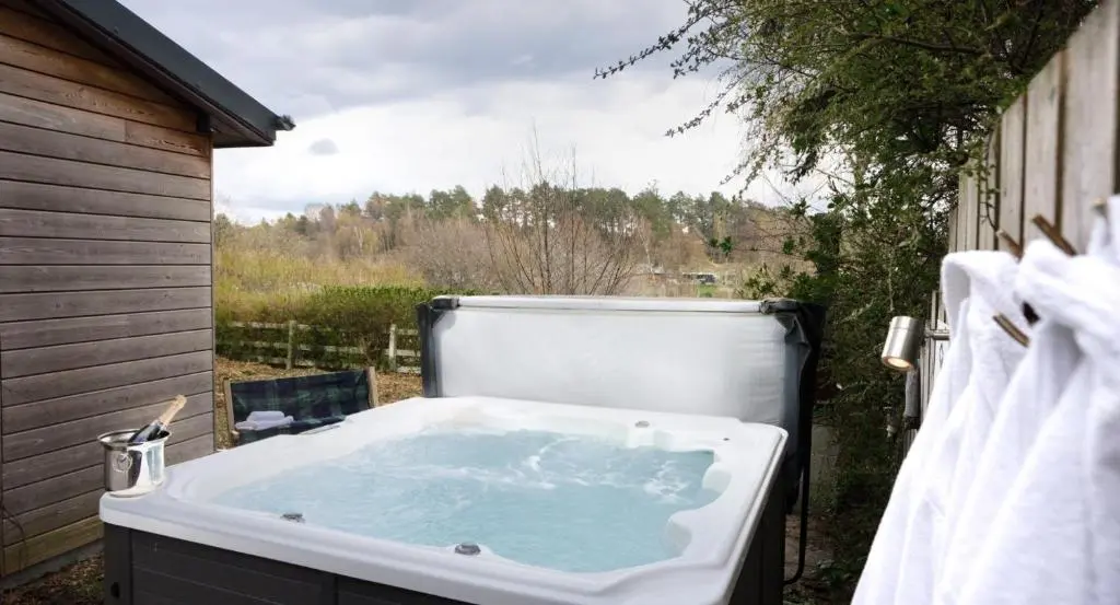 a bath tub sitting outside of a house at Salmon Run Lodge in Carrbridge