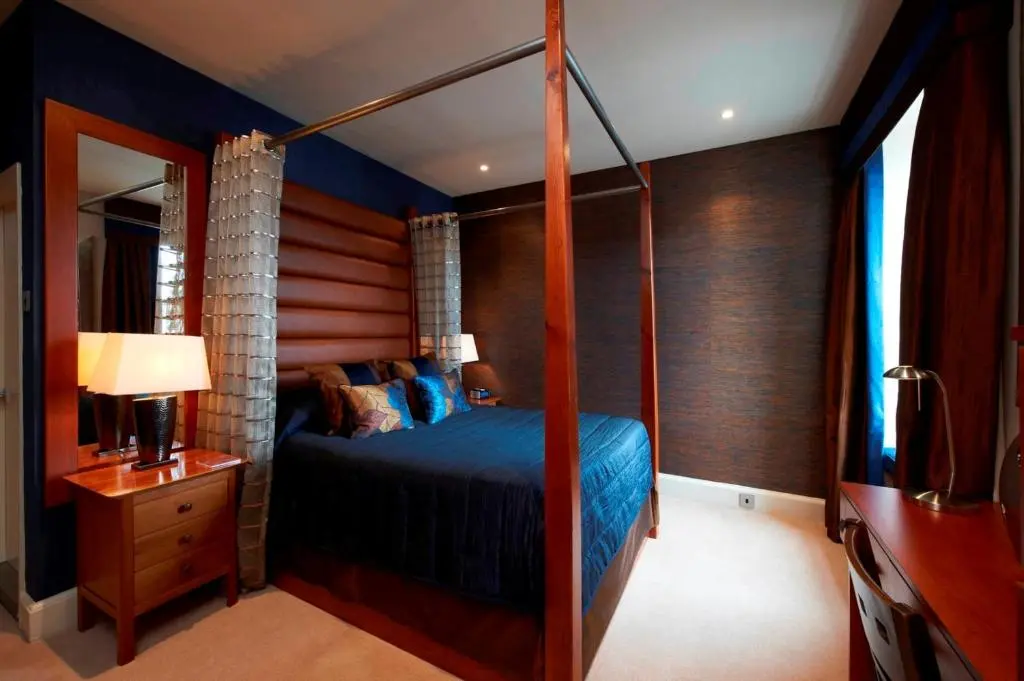 a bedroom with a canopy bed and a mirror at Heathmount Hotel in Inverness
