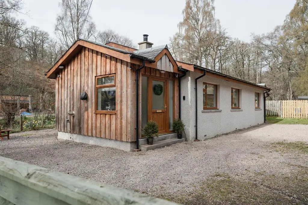 a small cabin with a door in a yard at Gardeners Cottage - Seasgair Lodges in Aviemore