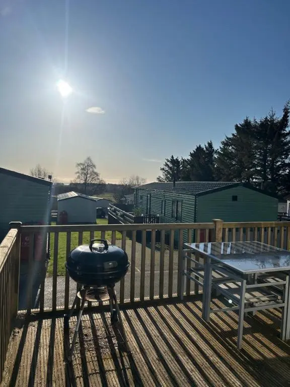 a bbq grill and a table on a deck at Uisge Beatha in Dornoch