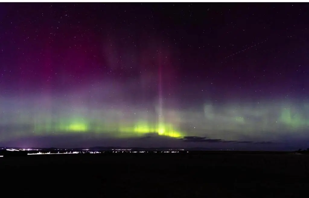 an aurora in the sky over a field at night at Uisge Beatha in Dornoch
