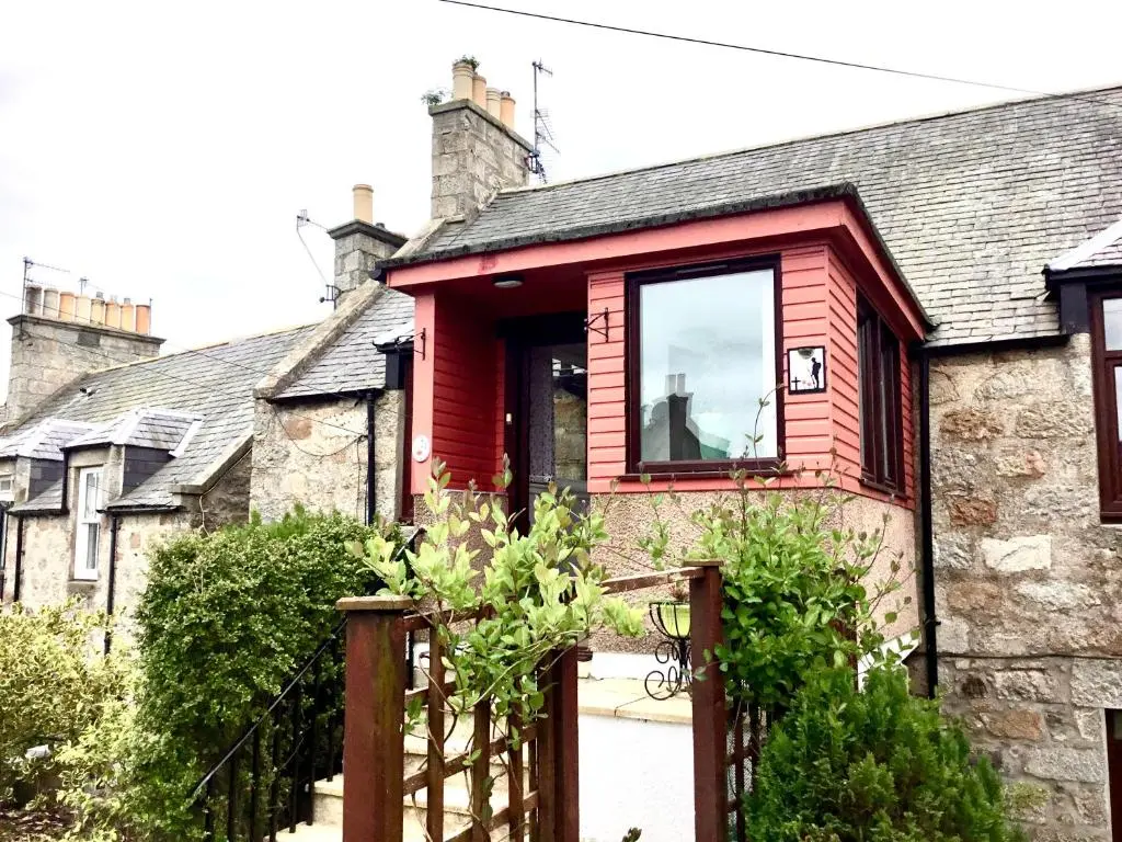 a red house with a gate in front of it at Bonnie Bide Huntly Aberdeenshire in Huntly