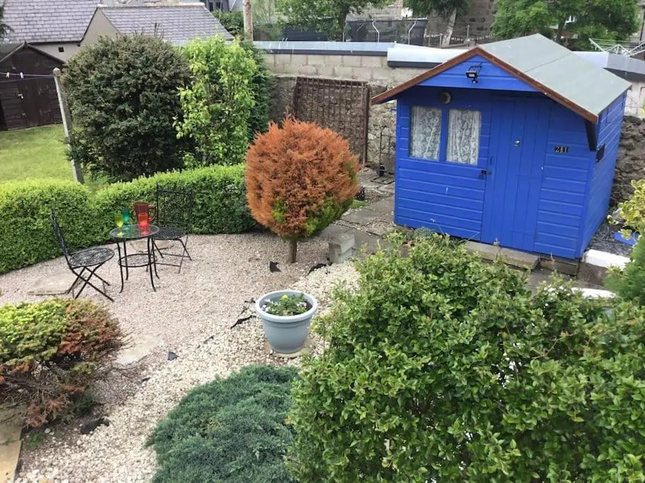 a blue dog house in the middle of a garden at Bonnie Bide Huntly Aberdeenshire in Huntly