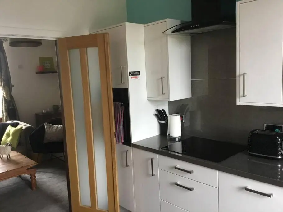 a kitchen with white cabinets and a black counter top at Bonnie Bide Huntly Aberdeenshire in Huntly