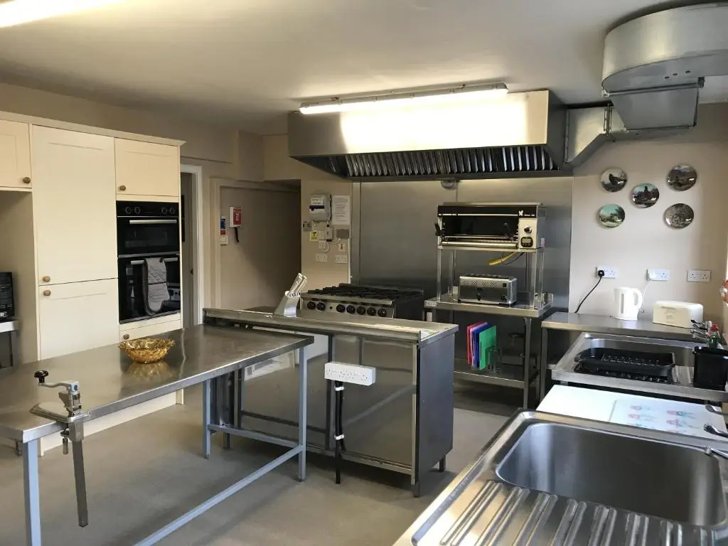 a large kitchen with stainless steel counters and appliances at The Struan Inn Self Catering Lodge in Struan