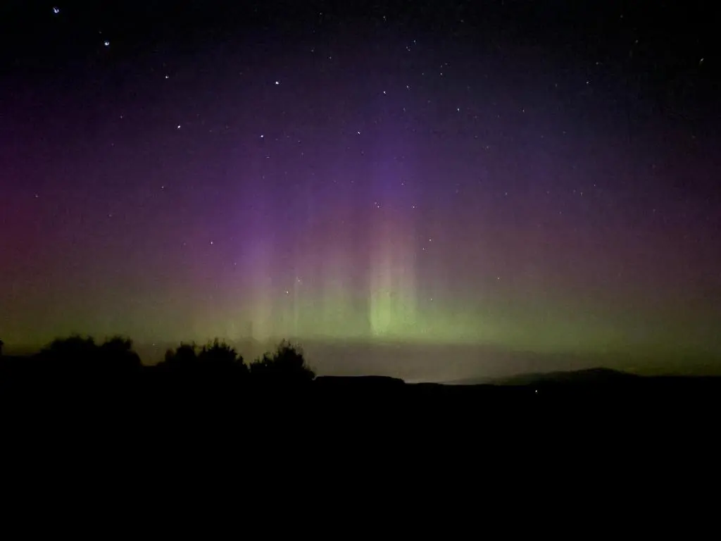 an aurora in the sky at night at Honey Cottage in Auchnarrow
