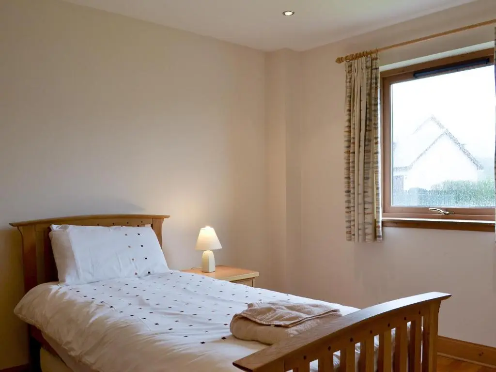 a bedroom with a bed and a window at 3 Allt Mor in Aviemore