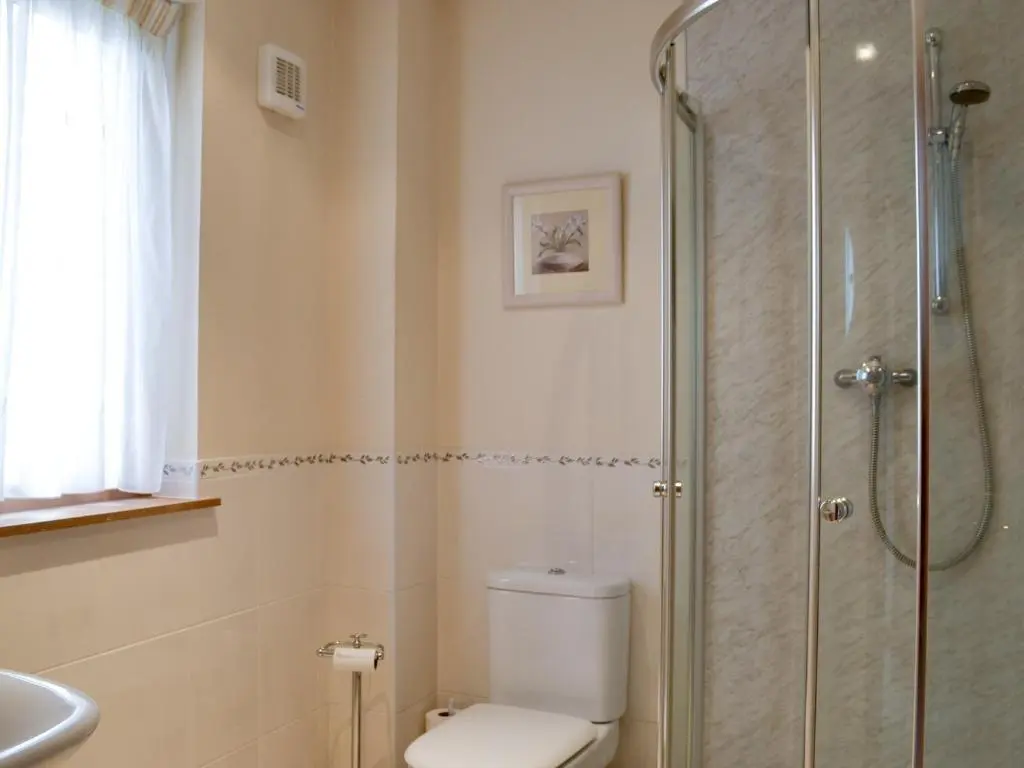 a bathroom with a toilet and a glass shower at 3 Allt Mor in Aviemore