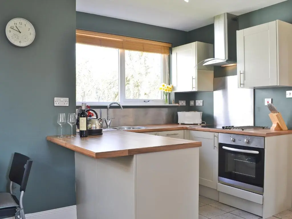a kitchen with a counter and a clock on the wall at Caberfeidh in Skye of Curr