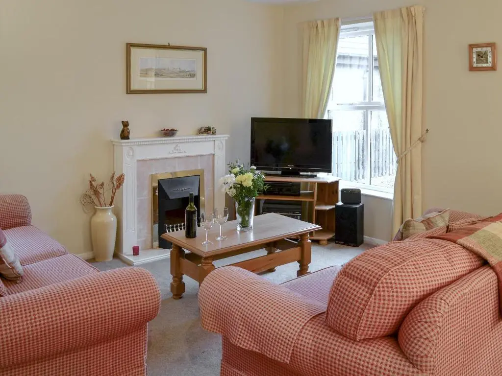 a living room with two couches and a television at Birch Tree Cottage in Aviemore