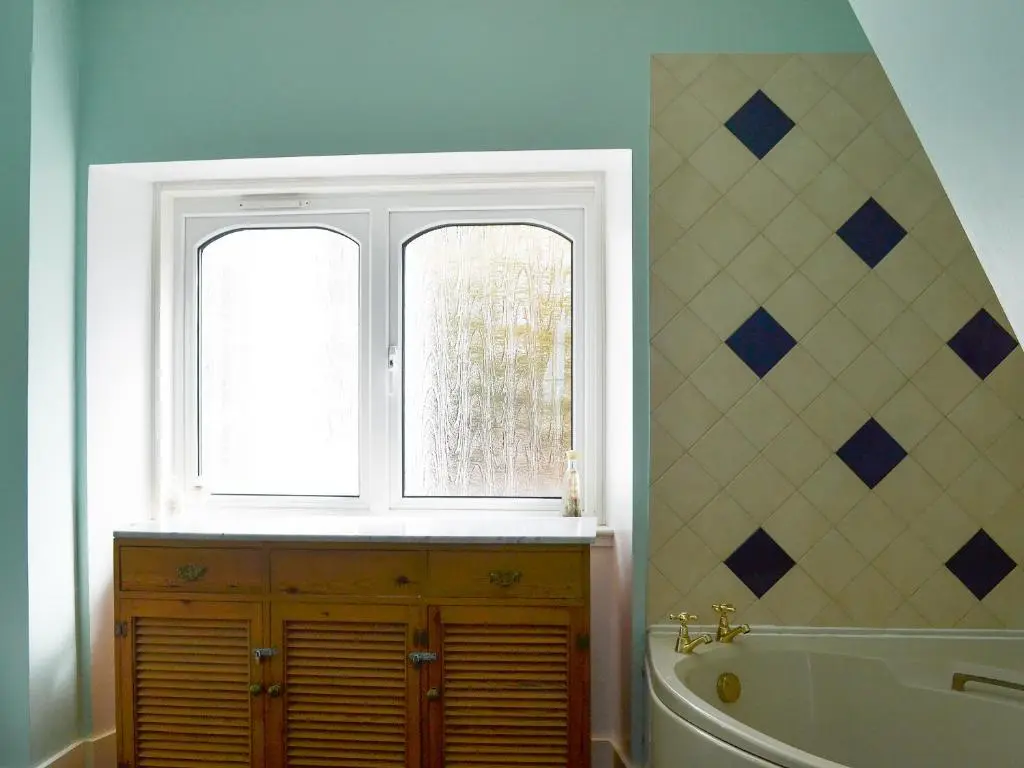 a bathroom with a bath tub and a window at Culcharry Cottage in Cawdor
