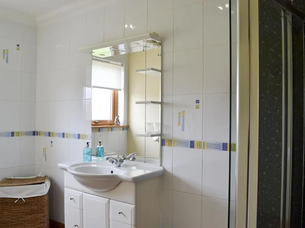 a bathroom with a sink and a mirror at Sandy Beach in Nairn
