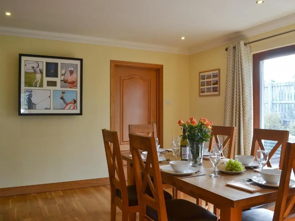 a dining room with a wooden table and chairs at Sandy Beach in Nairn